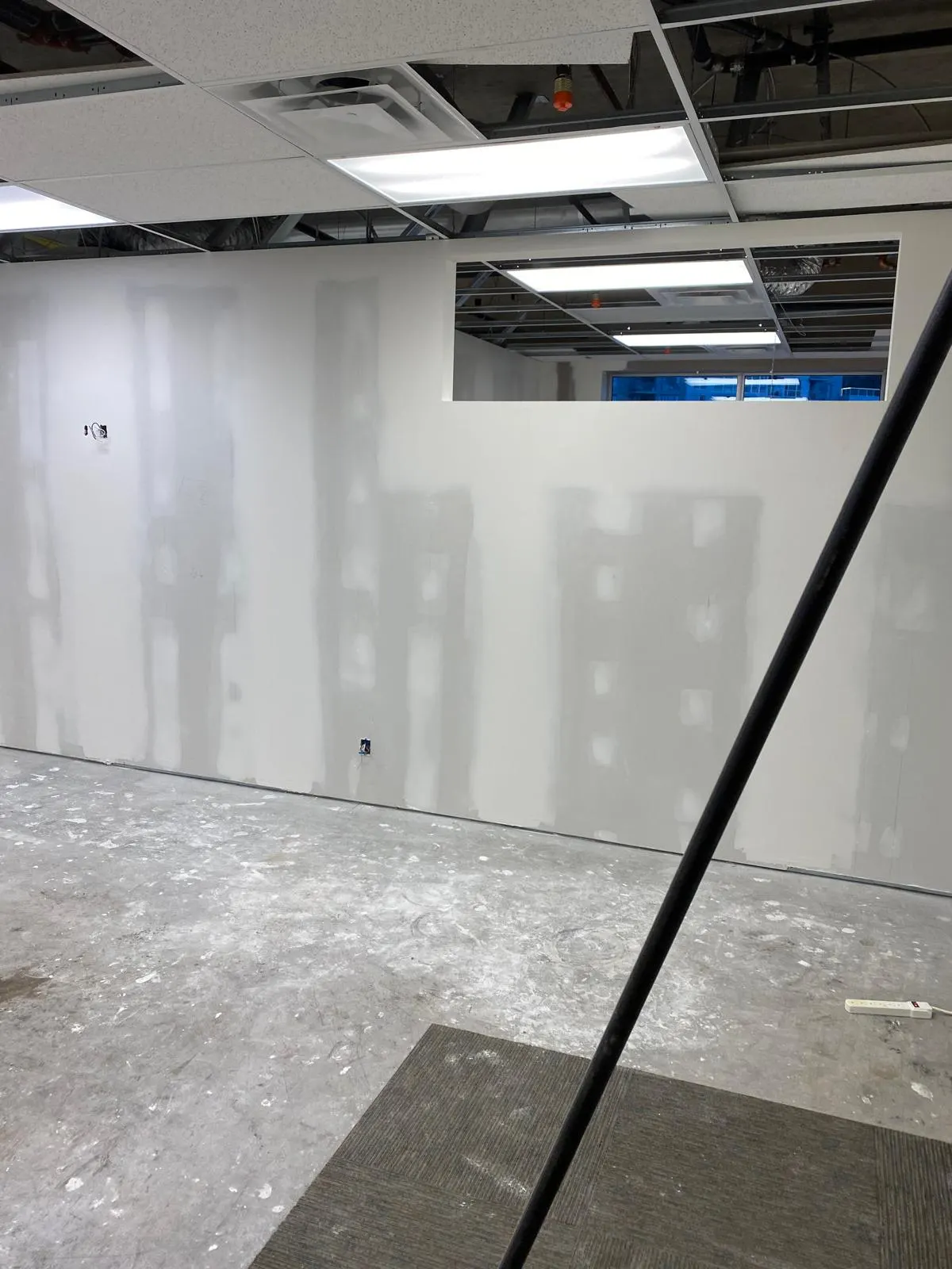 Finished, taped and sanded drywall office room with an interior transfer window, ready for paint