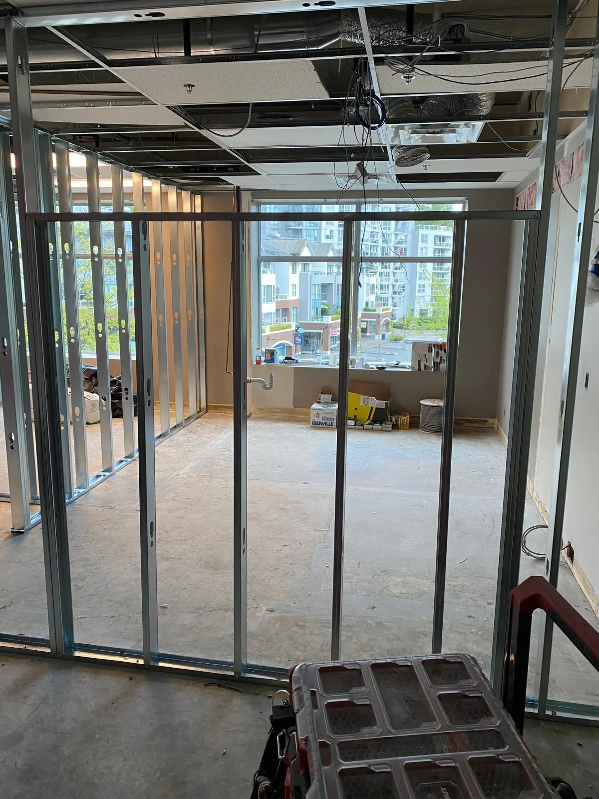 Open-concept framed office space with a floor-to-ceiling window overlooking downtown high-rises
