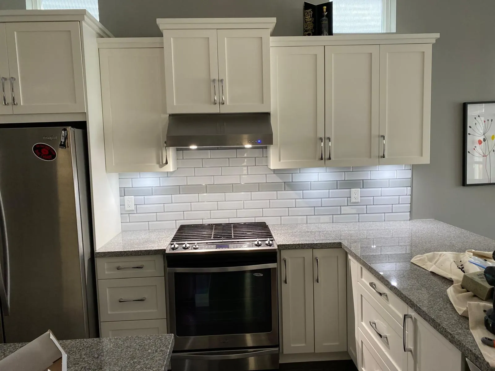 Finished kitchen with white shaker cabinets, white subway tile backsplash, and granite countertops