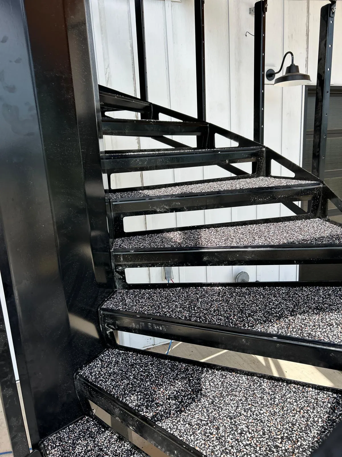 Exterior stairs resurfaced in a black, white and burnt-orange flecked poured rubber blend