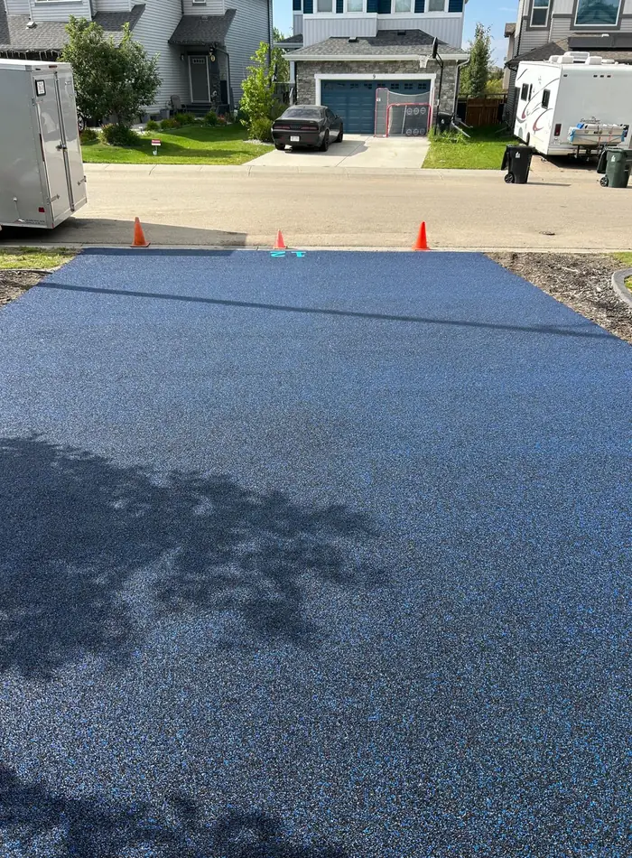 The same poured rubber driveway seen from the street, spanning the full width of the lot